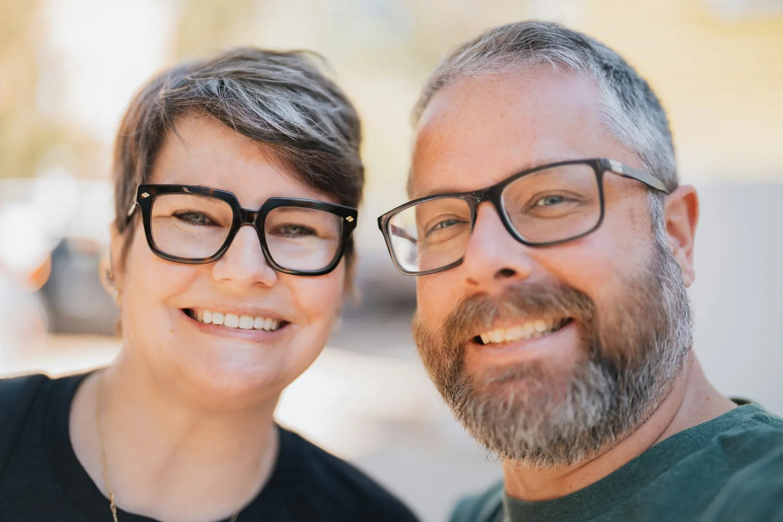 Smiling middle-aged couple wearing glasses outdoors